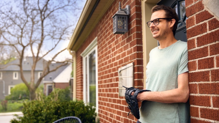 Adam standing at front door with baseball glove