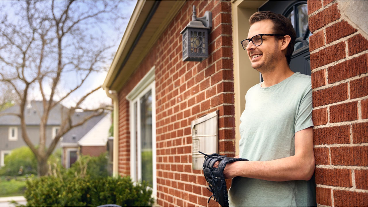 Adam standing at front door with baseball glove